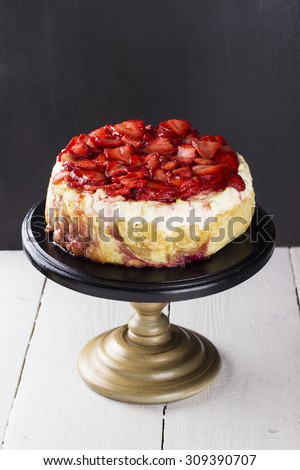 Strawberry cottage cheese cake on supports for pie on a wooden background