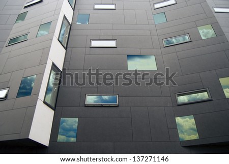 Modern building facade with sky reflecting in the windows