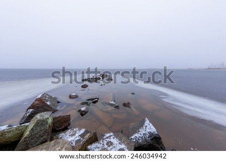 Foggy lake scenery with stones in january
