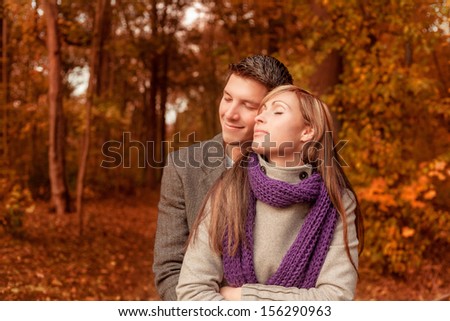 embracing autumn couple in woods