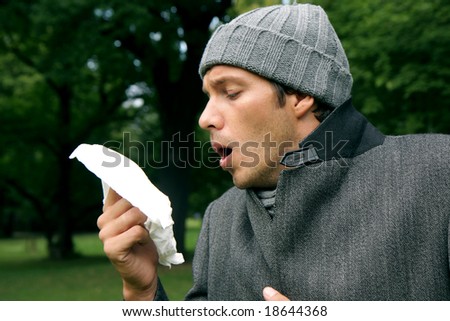 Sneeze man with tissue having virus