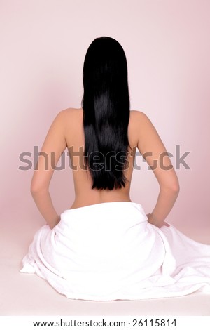Long hair woman sitting with towel showing back