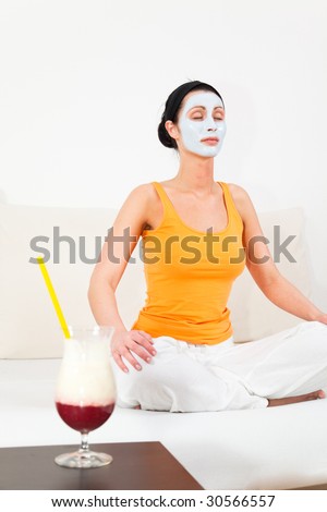 Spa and wellness at home woman with facial face mask doing yoga