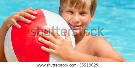Boy with water ball in swimming-pool smiling