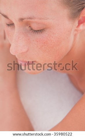 Close-up of face of a relaxing natural woman with closed eyes lying on towel
