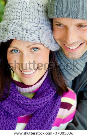 Embracing romantic couple in cold weather time with warm clothes cap and scarf