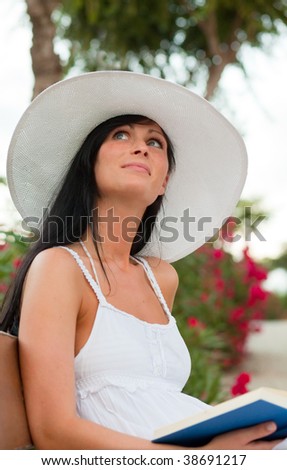 Book reading thinking smiling summertime woman in tropical garden