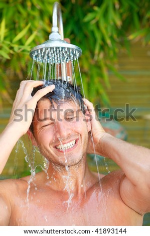 Showering happy healthy splash man in tropical vacation wellbeing wellness spa  resort hotel