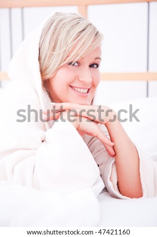 Smiling woman enjoying freetime weekend in bedroom in hotel suite pamper and towel bath robe