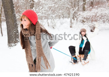 Winter friends smiling laughing while sledging