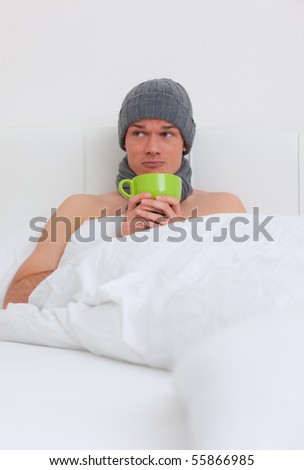Ill man lying in bed drinking tea