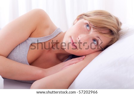 Dreaming female on weekend in bright bedroom