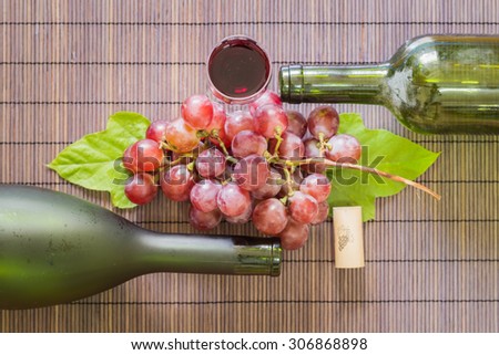 Still Life Wine Glass with bottle of red wine and  grape on wooden table