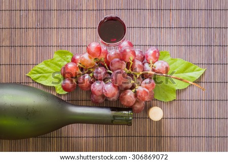 Still Life Wine Glass with bottle of red wine and  grape on wooden table