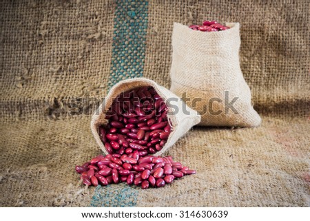 red beans in sack bags with pile of red beans on a sackcloth