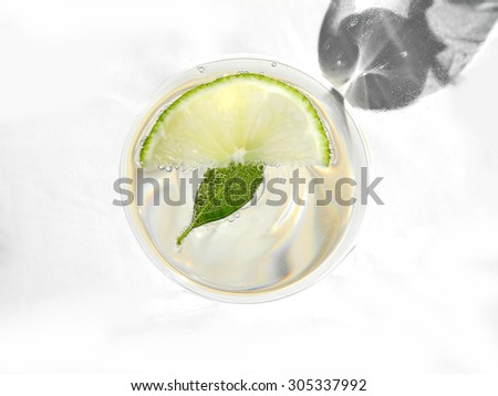 looking into a cocktail glass with sparkling wine, mint and lime/summer cocktail