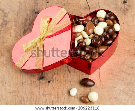 chocolate covered nuts and raisins in a heart-shaped gift box