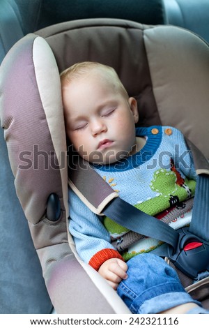 little boy sleeping in a car seat