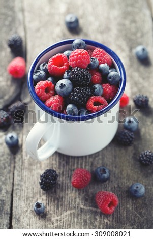 metallic mug with fresh forest berries