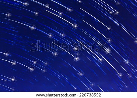 abstract long exposure of star trails with sparkle on blue night sky background