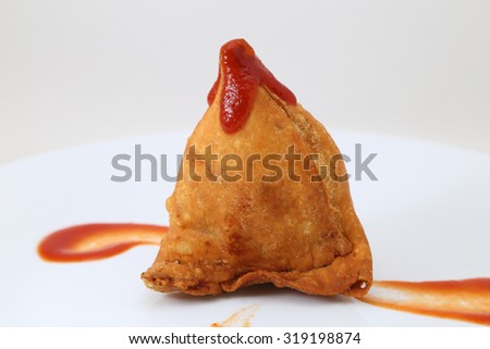 Vegetarian Samosa with sauce in a white ceramic plate. Indian traditional food.