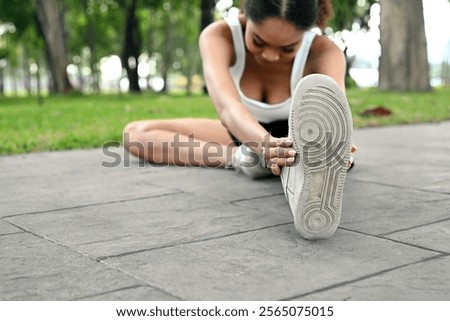 Similar – Image, Stock Photo Sportswoman stretching legs on stadium