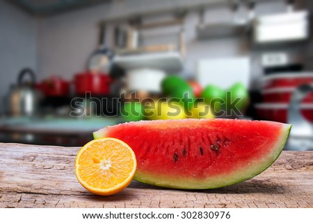 Watermelon slice and Orange slice on wooden and kitchen room background.
