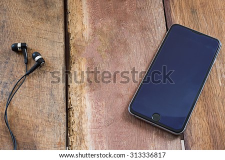 Empty screen of smart phone and eye phone on wood desk.