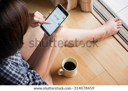 CHIANGMAI, THAILAND -SEP 6,2015:Relax time a girl touch on screen new Apple iPhone 6 Plus smartphone device open google application.