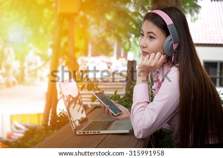 Business young woman listening to music on the music player in the outdoors.
