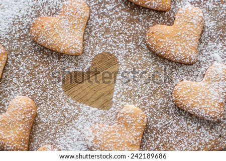 Heart shaped cookies with sugar powder on wood background