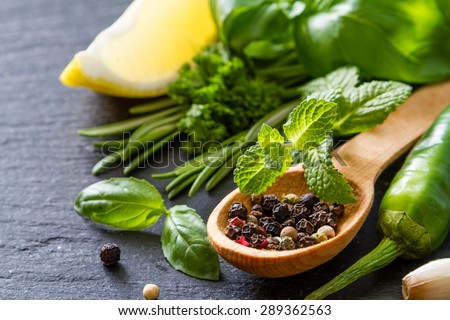 Herbs background - chili, lemon, mint, parsley, basil, garlic, ginger, rosemary,  dark stone background