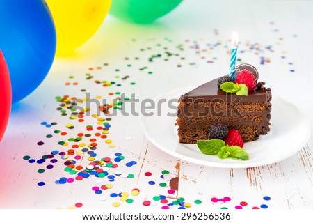 Birthday cake with candle, balloons, white wood background