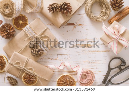 Christmas presents in rustic wrap, white wood background, toned