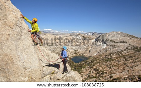 Climbing team struggles for the next grip on a challenging ascent.