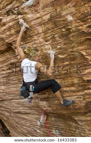 Young woman rock climbing in The Calico Hills, in Red Rock, Nevada.