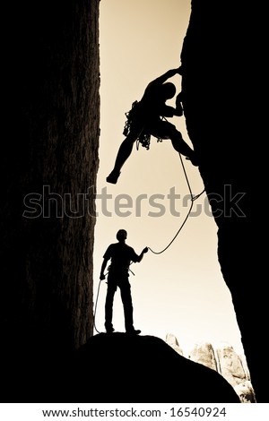 A team of rock climbers are silhouetted as they work their way up a chimney in Joshua Tree National Park.