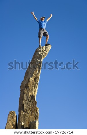 Man on the summit of a rock spire.
