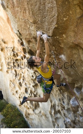 Female climber ascending an overhanging rock face in Joshua Tree National Park.