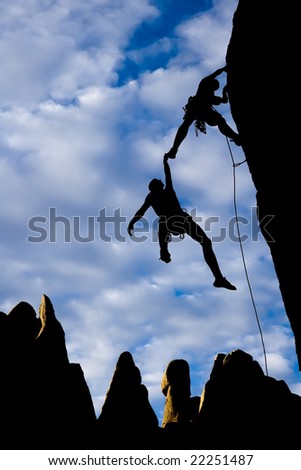 Team of climbers in trouble clinging to a cliff for dear life in The Sierra Nevada Mountains, California.