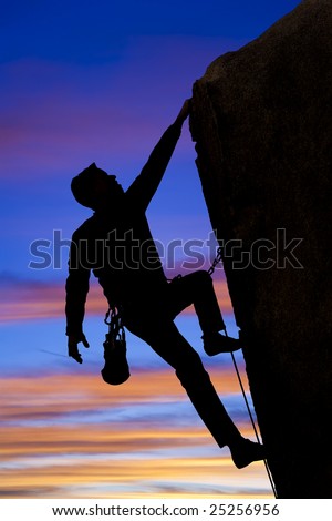 A climber clings to the side of an overhanging rock spire in The Sierra Nevada Mountains, California.