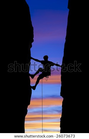 A climber is silhouetted as he reaches across a gap in the rock, in the Sierra Nevada  Mountains, California.