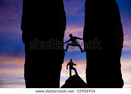 A team of climbers are silhouetted as they work their way up a gap between two pinnacles in the Sierra Nevada  Mountains, California.