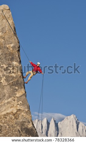 Rock climber rappels from the summit after a successful ascent.