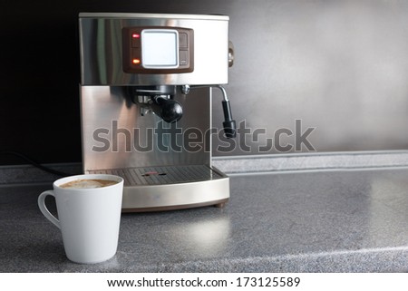 Coffee machine and freshly made cup of latte of table