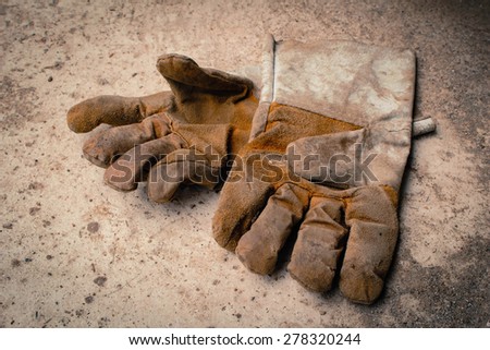 soft focus image of dirty leather gloves on the floor in vintage tone