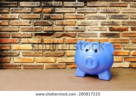 blue piggy bank on old dirty brick wall background