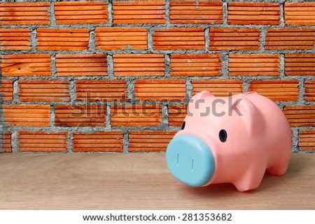 pink piggy bank on orange brick wall background