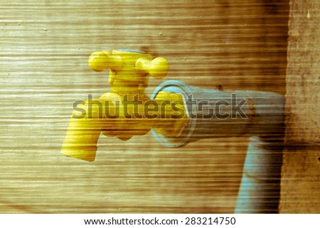 yellow plastic faucet on grey fiber glass background