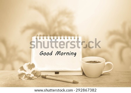 notepad and black coffee on blur palm tree and blue sky background